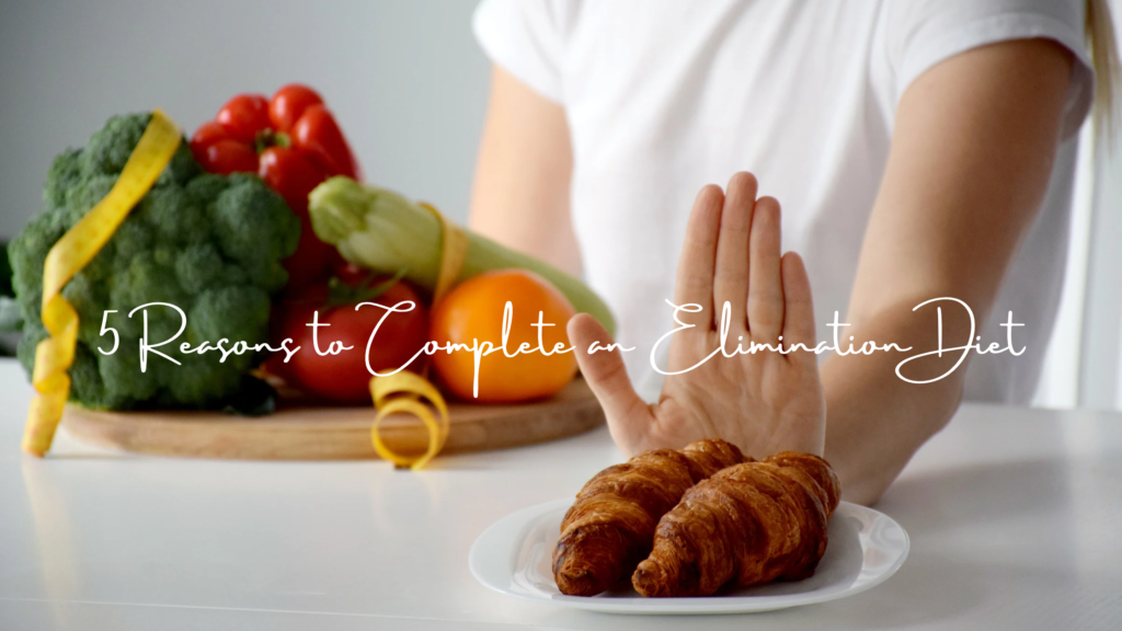 a plate of vegetables in the background with a hand covering a plate of bread